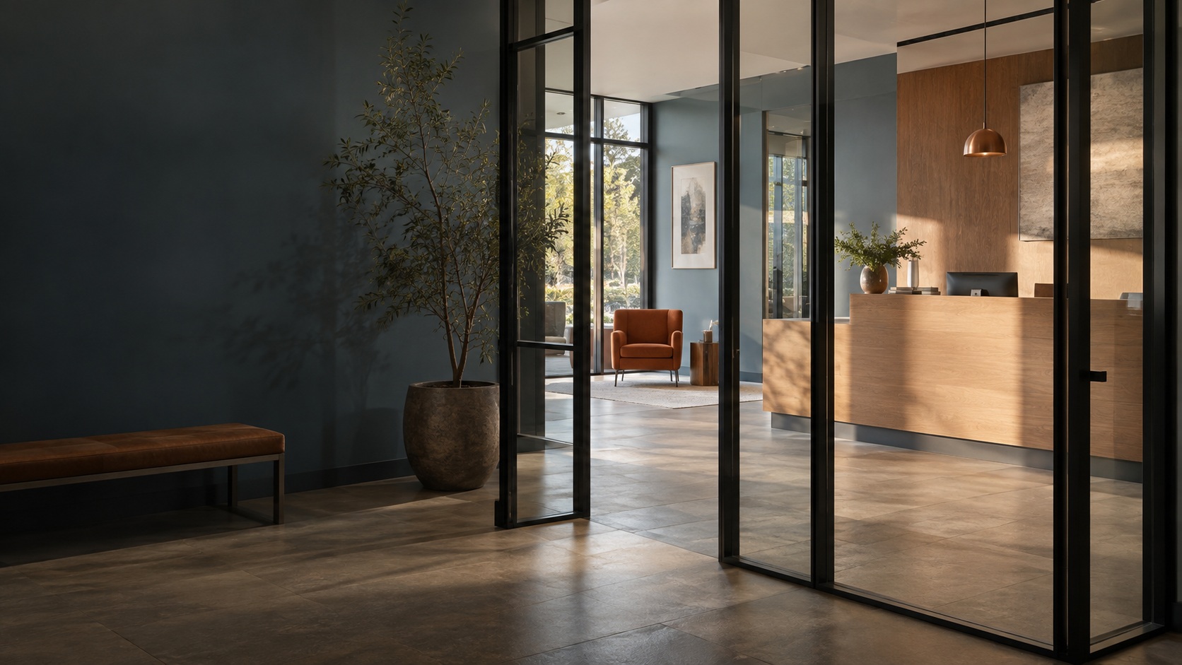 Sunlit reception with slate blue walls, warm oak and glass partitions